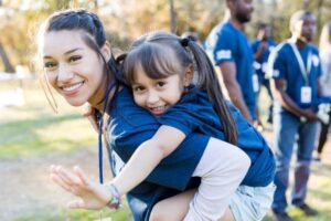 Loren joyfully spending time with a child at the orphanage, reflecting her love for helping children during the Christmas season.