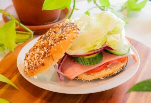 Ham & Swiss bagel from Konditorei Cafe with ham, Swiss cheese, onion, tomato, cucumber, lettuce, mayo, and mustard, served on a toasted bagel of your choice. 